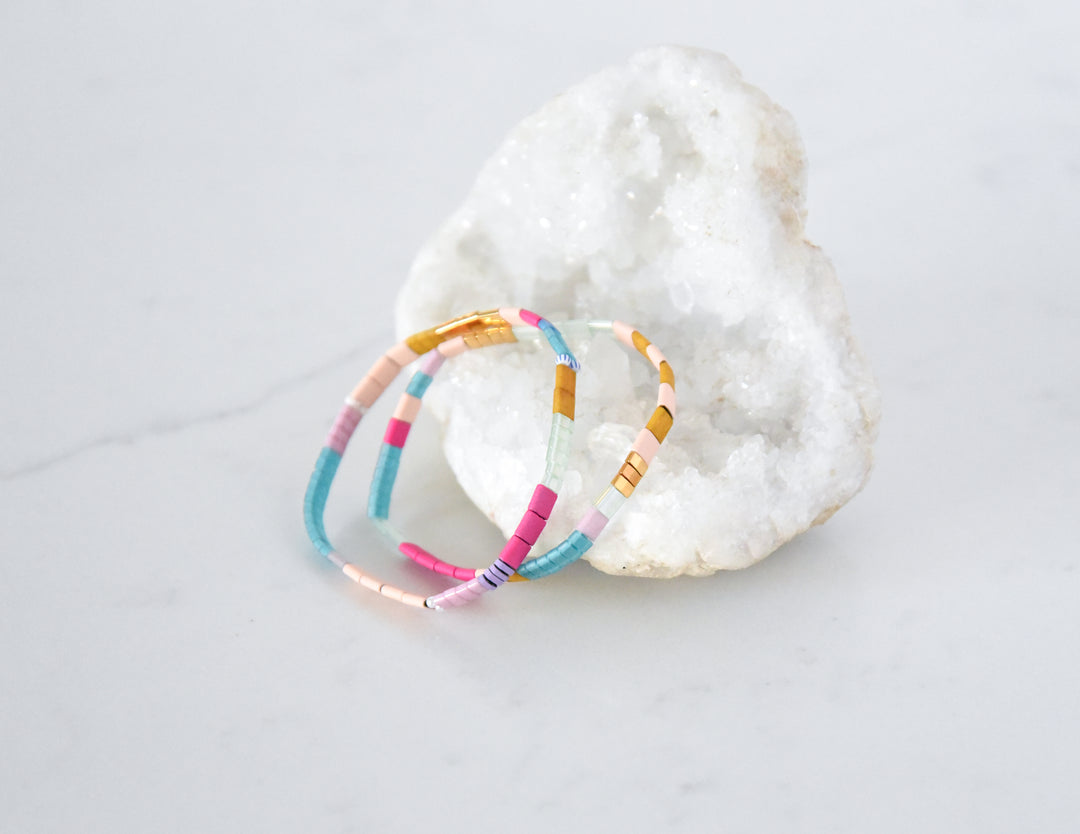 Two bright and beachy stretch glass bead bracelets from the BALBOA Bracelet Stack, perfect for women. Shop Current.