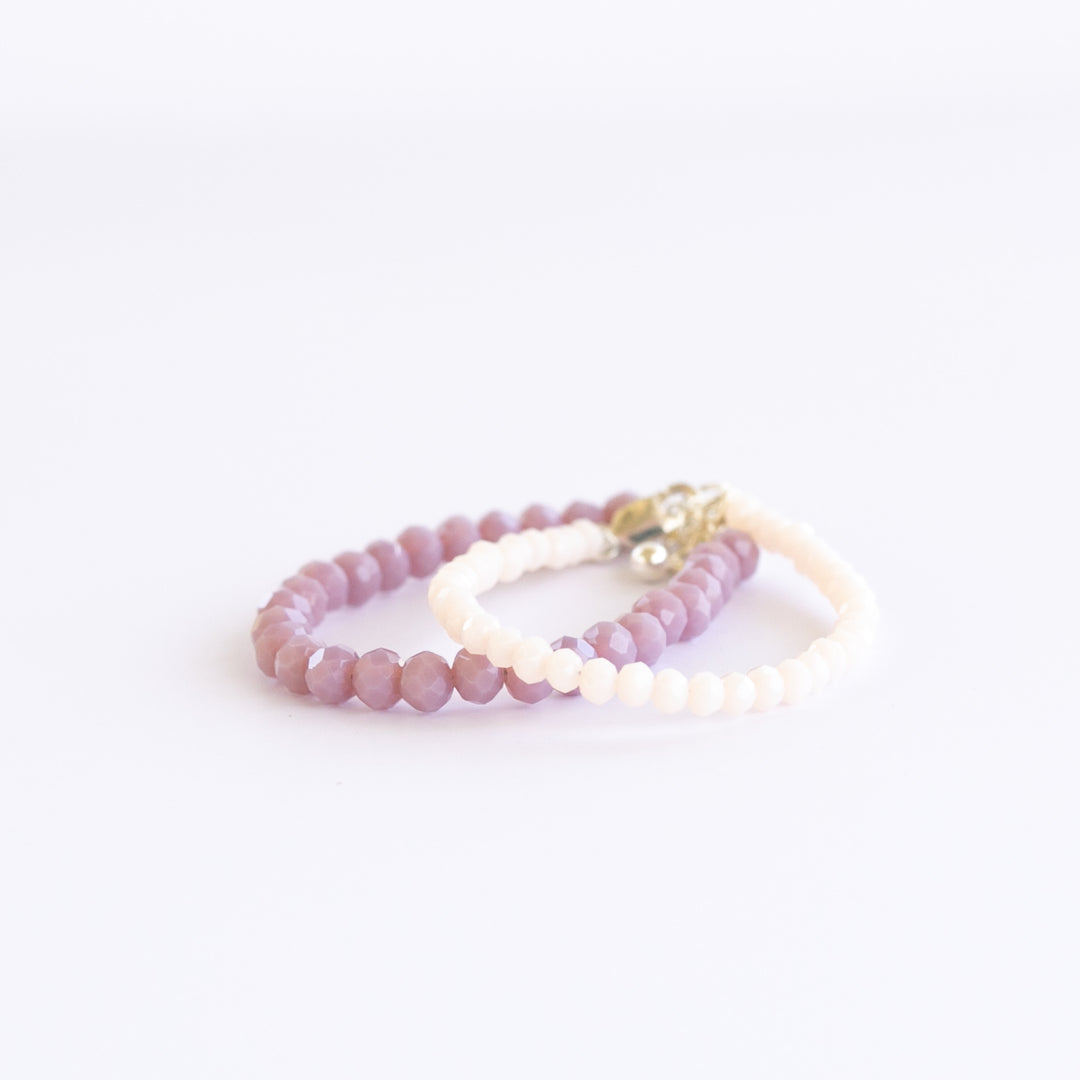 LILAC GEM Baby Bracelet Set featuring round polished jade stones and Czech faceted beads in playful lilac and cream tones for baby girls. Shop Current.