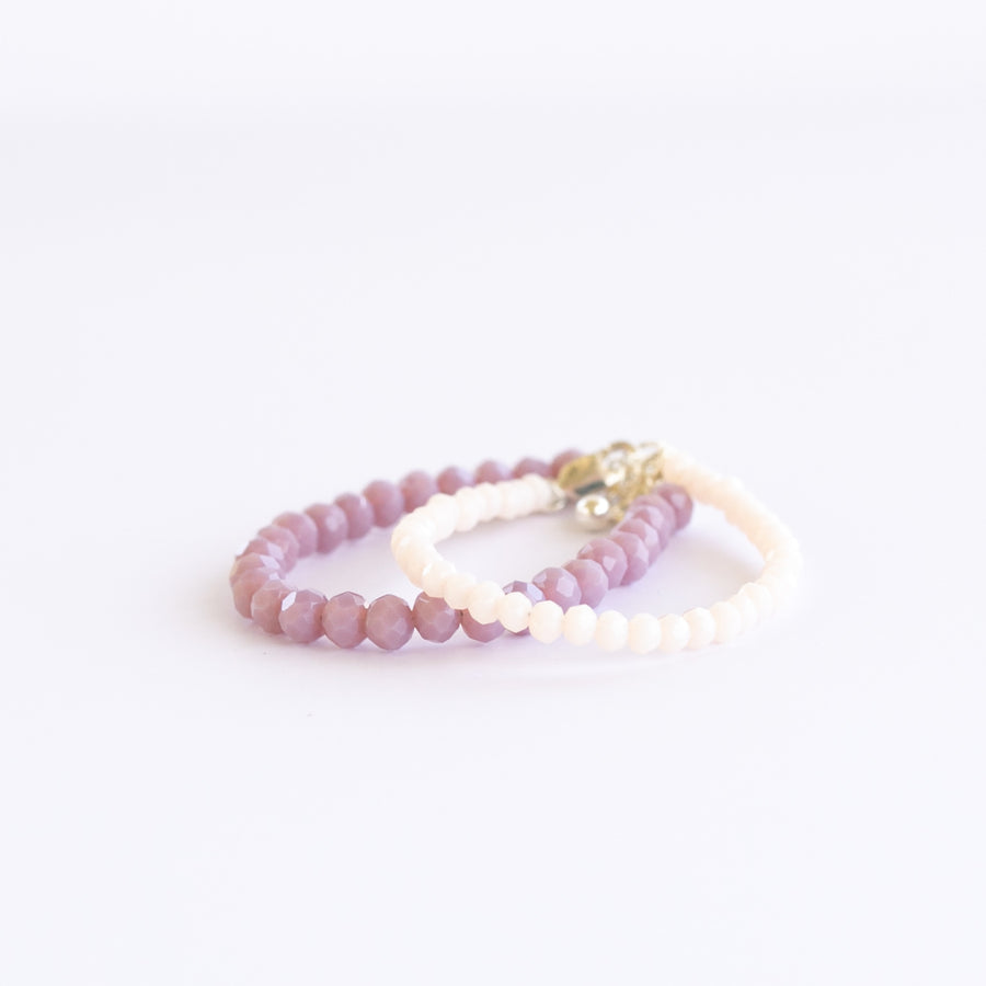 LILAC GEM Baby Bracelet Set featuring round polished jade stones and Czech faceted beads in playful lilac and cream tones for baby girls. Shop Current.