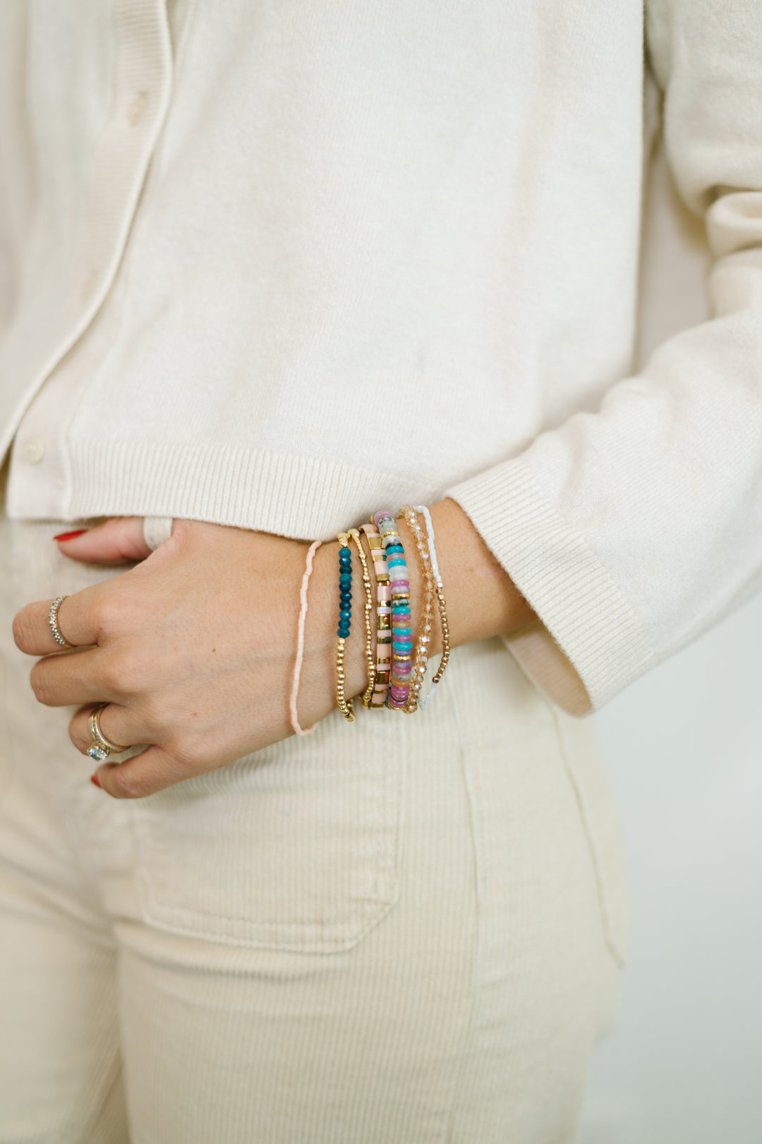 The Sapphire Bracelet stack includes gemstones, gold accents, and sparkling glass beads with a touch of pink, blue, and jewel tones. Add a pop of color to your holiday!