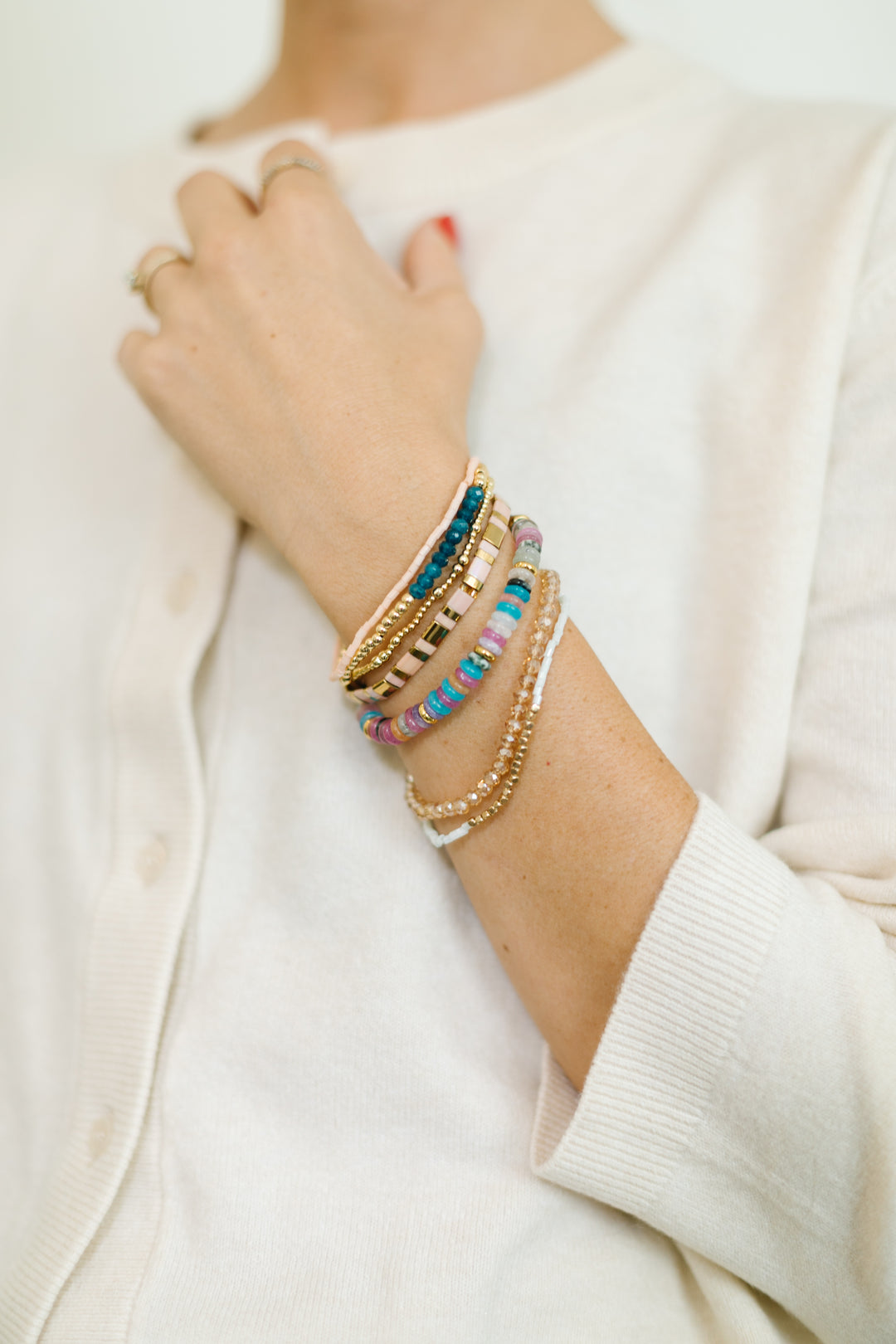 The Sapphire Bracelet stack includes gemstones, gold accents, and sparkling glass beads with a touch of pink, blue, and jewel tones. Add a pop of color to your holiday!