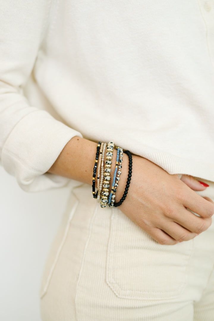 Stone Bracelet Stack  features a mix of black and white stone bracelets, pops of black, blue, and gold- The perfect addition to any outfit!