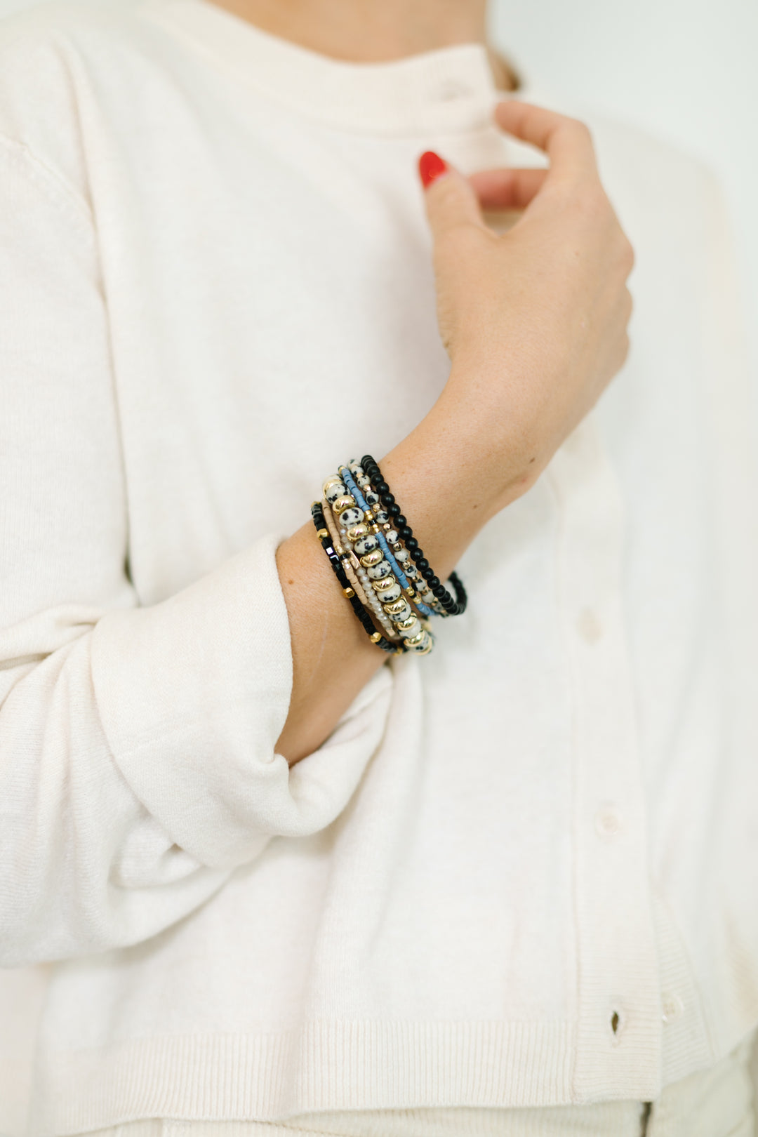 Stone Bracelet Stack  features a mix of black and white stone bracelets, pops of black, blue, and gold- The perfect addition to any outfit!