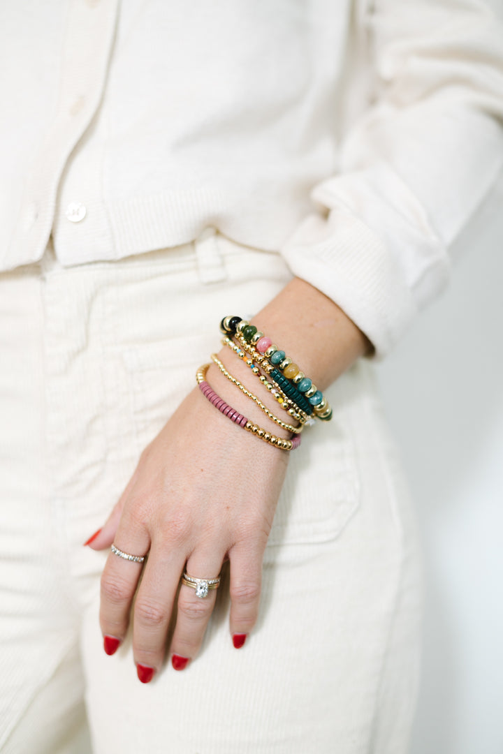 Boho-inspired Jewel Tone Bracelet Set featuring rich teal, pink, green,  and gold tones. Six stretchy bracelets, stacked together for a layered, chic look.