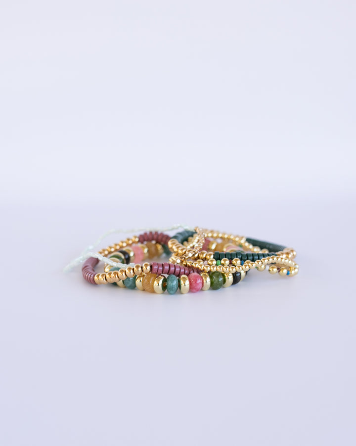 Boho-inspired Jewel Tone Bracelet Set featuring rich teal, pink, green,  and gold tones. Six stretchy bracelets, stacked together for a layered, chic look.