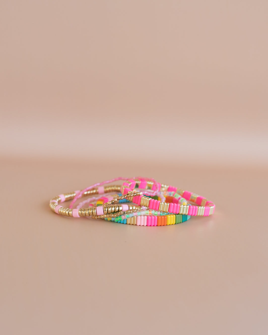 Add some color to your holiday with our Merry and Bright bracelet stack. A mix of Neon colors and gold, with pastel beaded bracelets.