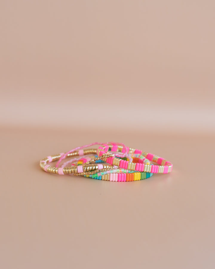 Add some color to your holiday with our Merry and Bright bracelet stack. A mix of Neon colors and gold, with pastel beaded bracelets.