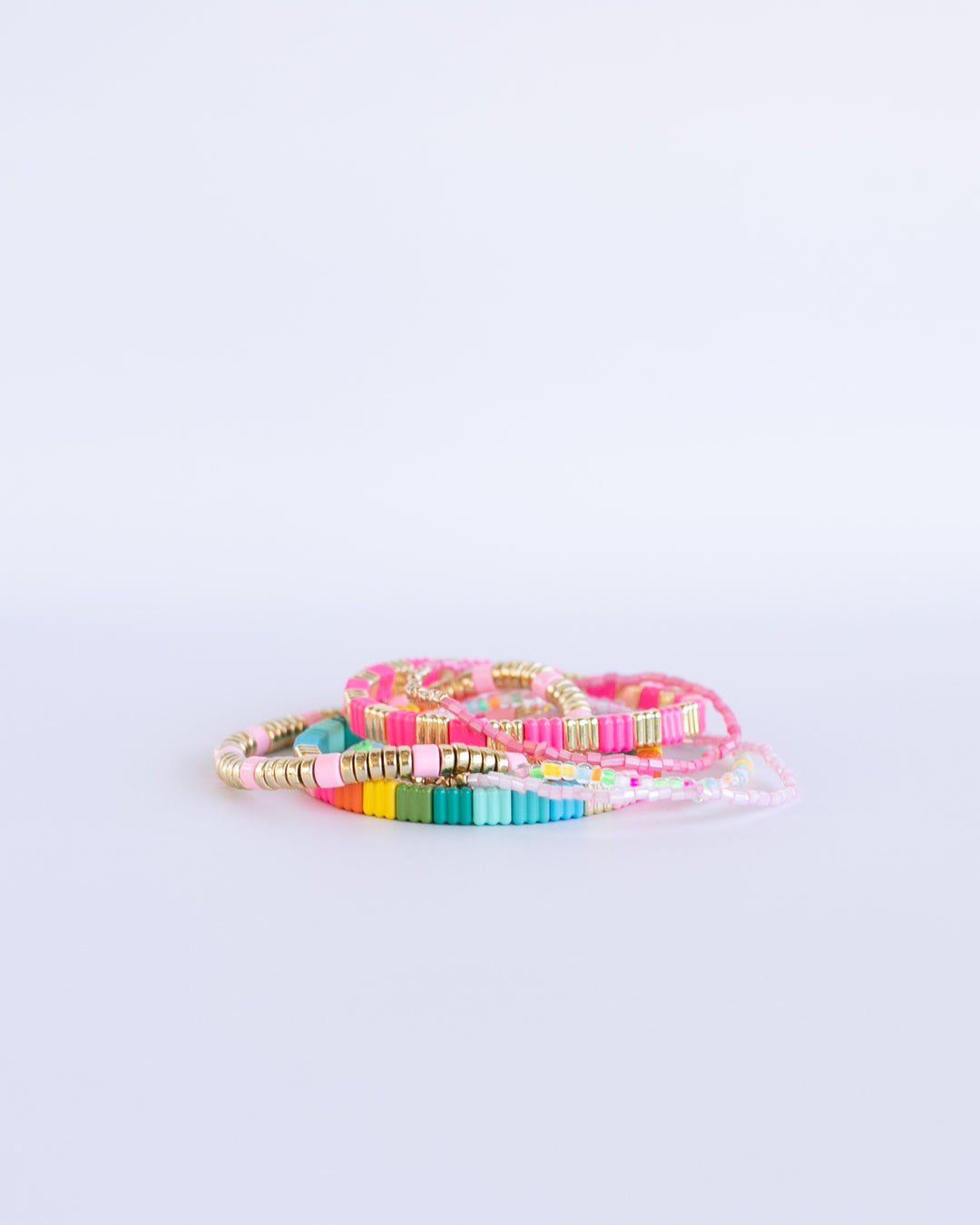 Add some color to your holiday with our Merry and Bright bracelet stack. A mix of Neon colors and gold, with pastel beaded bracelets.