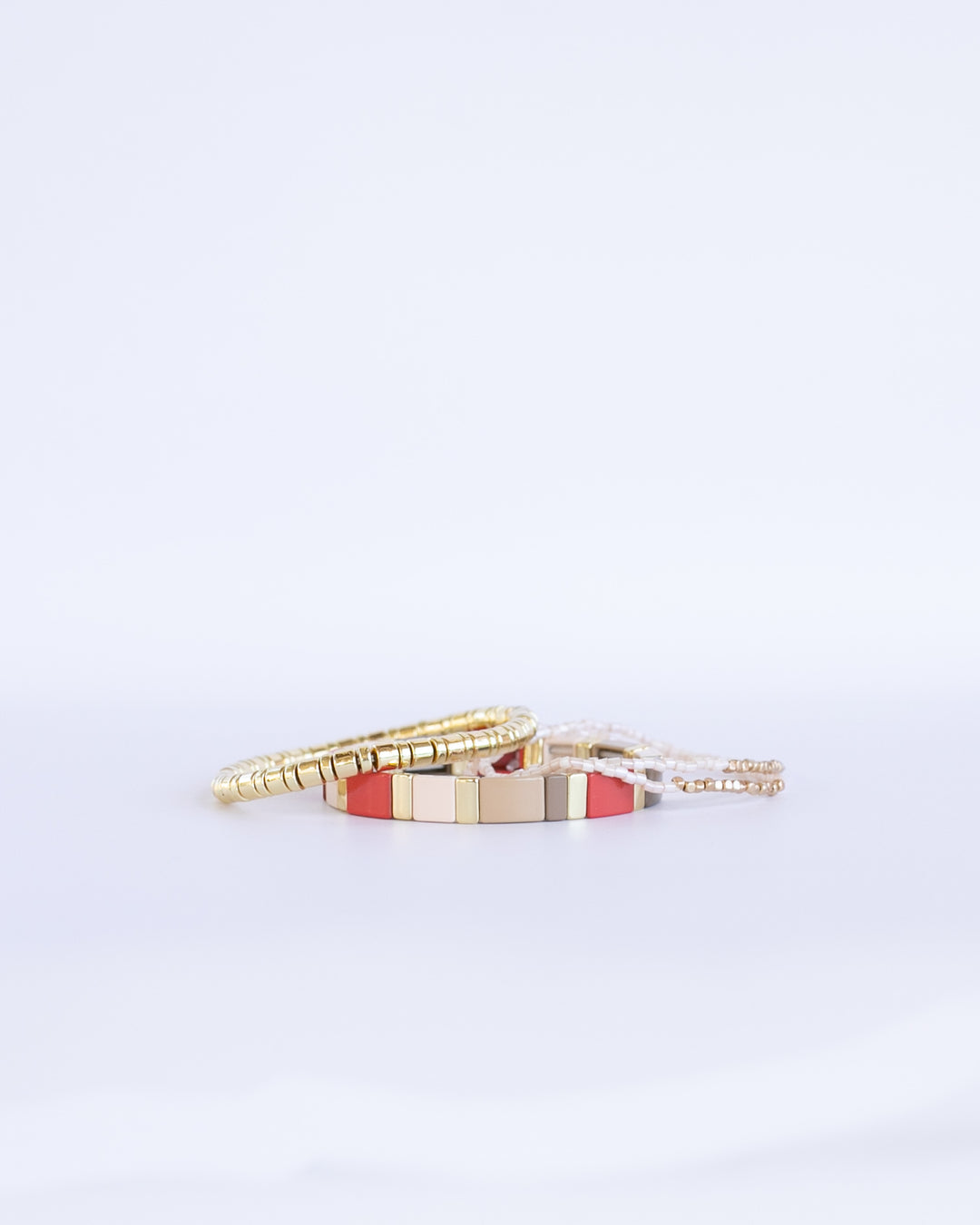 RED CHUNKY MONOCHROME Bracelet stack with red and soft neutral colors paired with gold enamel bracelet 